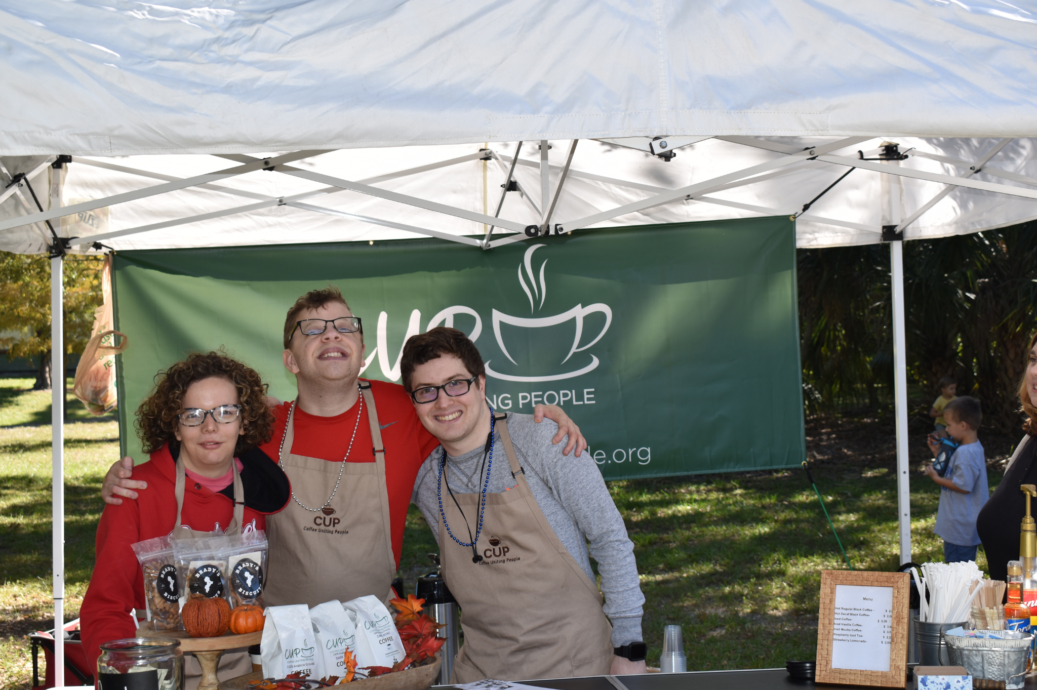 Three CUP employees smiling under a tent